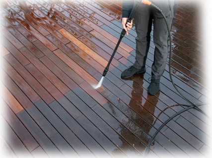 A person using a power washer on the ground.